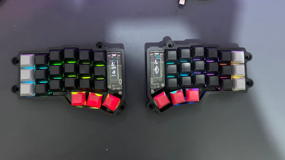 Corne MX wireless split keyboard — black case with black and white keycaps and red thumb keys, per-key RGB lighting, top-down view