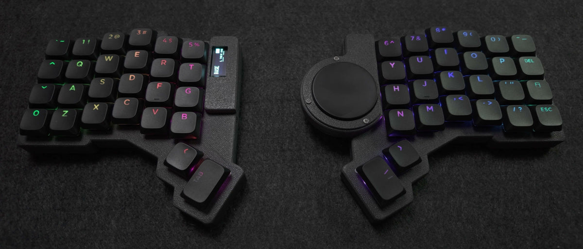 Parix 52, both halves apart on a desk pad, low angle, no cable between them, black keycaps lit