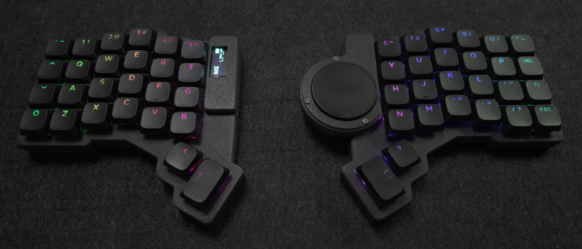 Parix 52, both halves apart on a desk pad, low angle, no cable between them, black keycaps lit